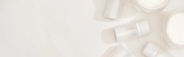 Top view of glasses of homemade yogurt near containers with starter cultures on white background, panoramic shot — Stock Photo