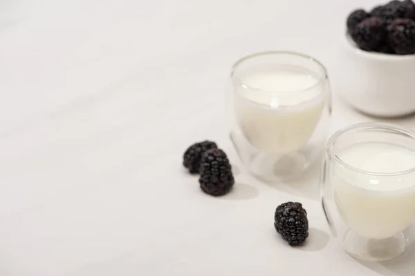 Hochwinkelblick auf Gläser mit hausgemachtem Joghurt und Brombeeren auf weißem Hintergrund — Stockfoto