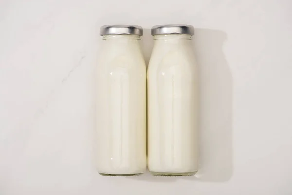 Vue du dessus des bouteilles de yaourt maison sur fond blanc — Photo de stock