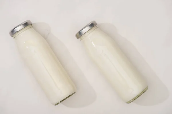 Vista superior de garrafas de iogurte sobre fundo branco — Fotografia de Stock