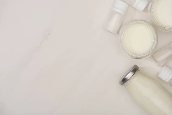 Vue du dessus de la bouteille et des verres de yaourt fait maison et des conteneurs avec des cultures de démarrage sur fond blanc — Photo de stock