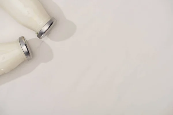 Vista dall'alto di bottiglie di yogurt fatto in casa su bianco — Foto stock