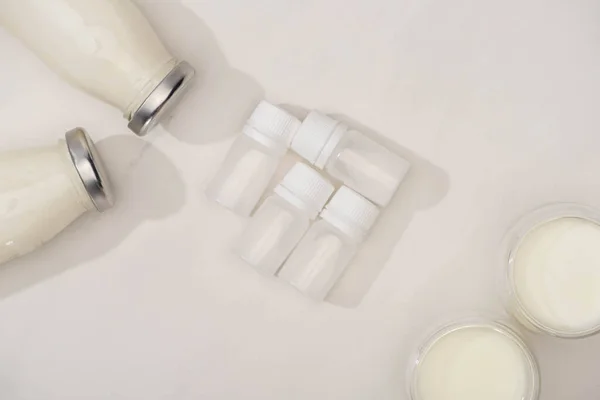 Top view of containers with starter cultures with bottles and glasses of yogurt on white background — Stock Photo