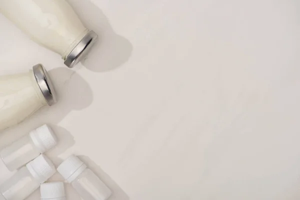 Vue du dessus des conteneurs avec des cultures de démarrage et des bouteilles de yaourt maison sur blanc — Photo de stock