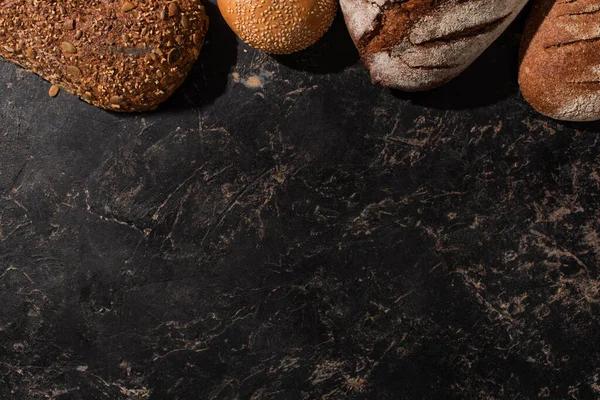 Top view of fresh baked bread on stone black surface — Stock Photo