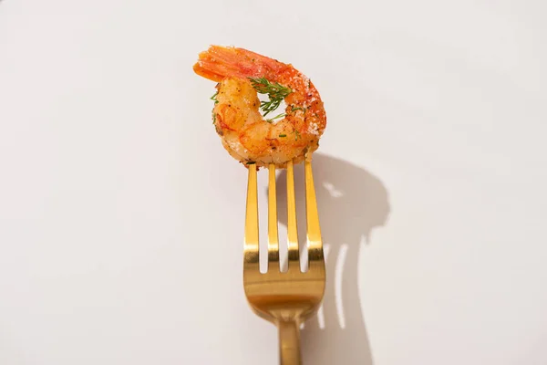 Top view of fried shrimp on golden fork on white background — Stock Photo