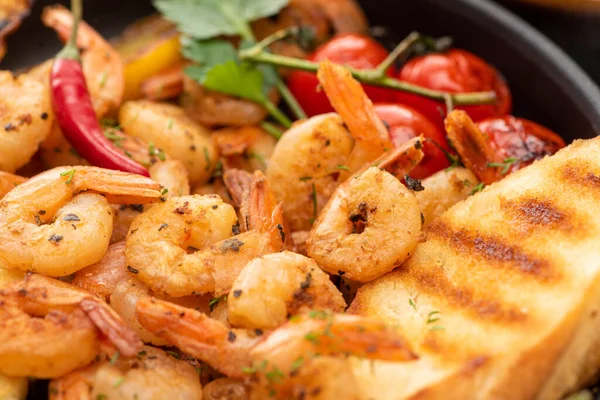 Close up view of fried shrimps with grilled bread, tomatoes, chili peppers — Stock Photo
