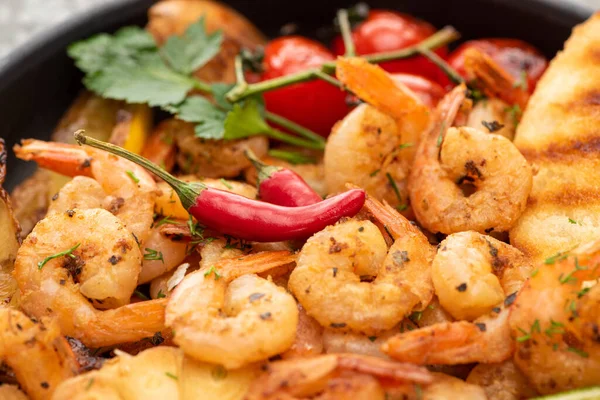 Vista de cerca de camarones fritos con pan a la parrilla, tomates, chiles - foto de stock