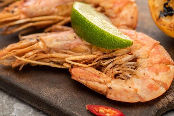Close up view of fried shrimps with chili and lime on wooden board — Stock Photo