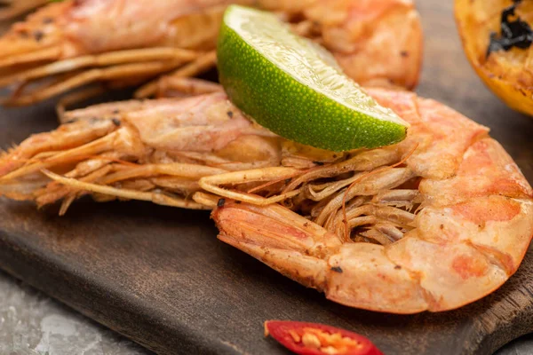 Vista ravvicinata di gamberetti fritti con peperoncino e lime su tavola di legno — Foto stock