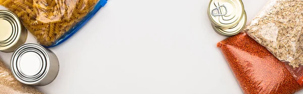 Imagem panorâmica de latas e grumos em sacos com zíper sobre fundo branco, conceito de doação de alimentos — Fotografia de Stock