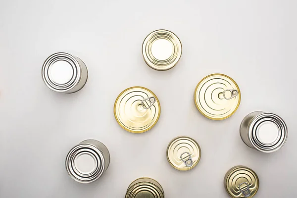 Vista superior de latas con alimentos enlatados sobre fondo blanco, concepto de donación de alimentos - foto de stock