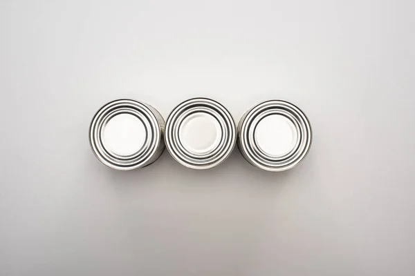 Flat lay with silver cans on white background, food donation concept — Stock Photo