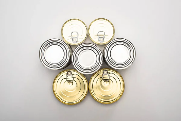 Vista superior de latas con alimentos enlatados sobre fondo blanco, concepto de donación de alimentos - foto de stock