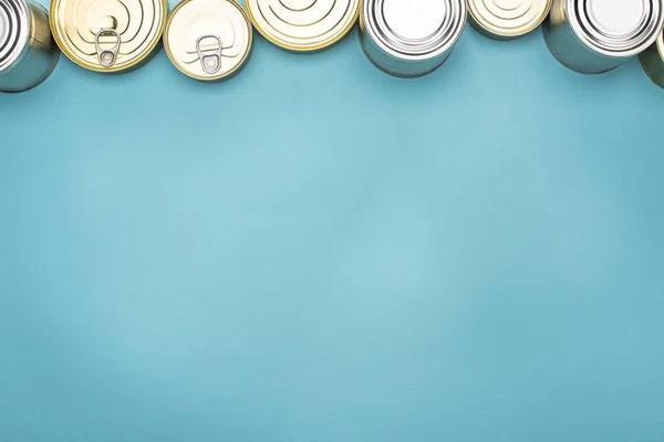 Вид зверху банок на синьому фоні з простором для копіювання, концепцією пожертвування їжі — стокове фото