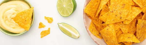 Top view of corn nachos with lime and cheese sauce on white background, panoramic shot — Stock Photo