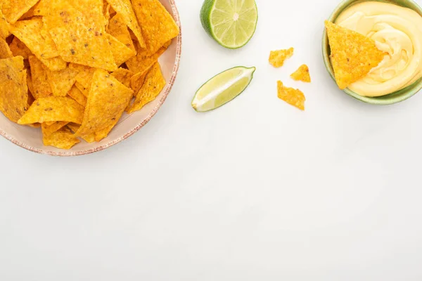 Ansicht von Mais-Nachos mit Limetten-Käse-Sauce auf weißem Hintergrund — Stockfoto