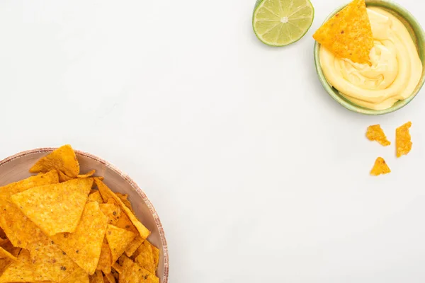Vista dall'alto di nachos di mais con salsa di lime e formaggio su sfondo bianco — Foto stock
