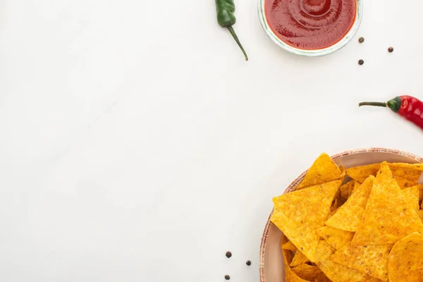 Top view of corn nachos with chili peppers, ketchup on white background — Stock Photo