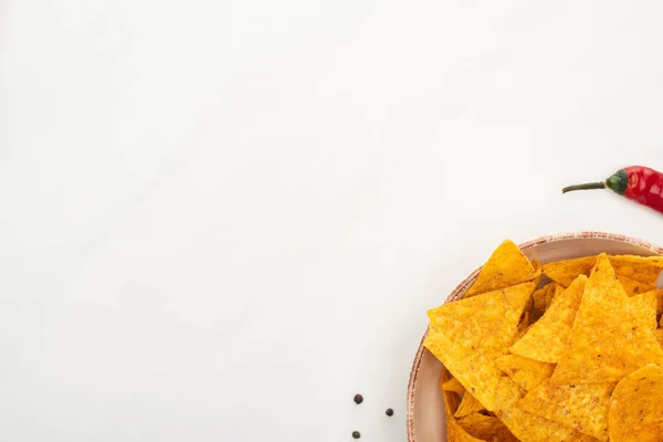 Vista superior de nachos de milho com pimenta vermelha no fundo branco — Fotografia de Stock