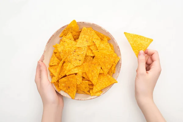 Cropped view of woman holding bowl of corn nachos with on white background — Stock Photo