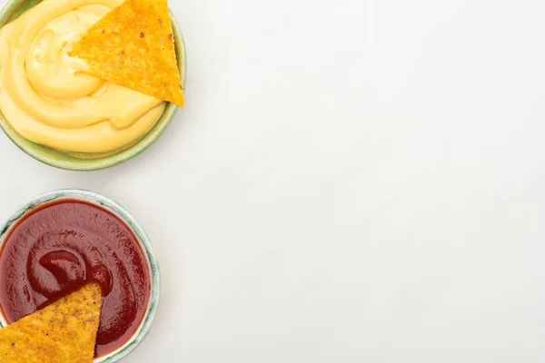 Vue du dessus des nachos de maïs avec sauce au fromage et ketchup sur fond blanc — Photo de stock