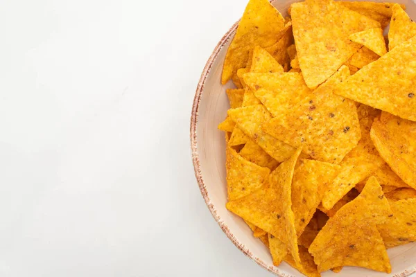 Vista dall'alto di nachos di mais in ciotola su sfondo bianco — Foto stock