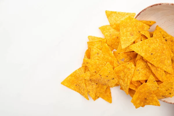 Vista dall'alto di nachos di mais sparsi da ciotola su sfondo bianco — Foto stock