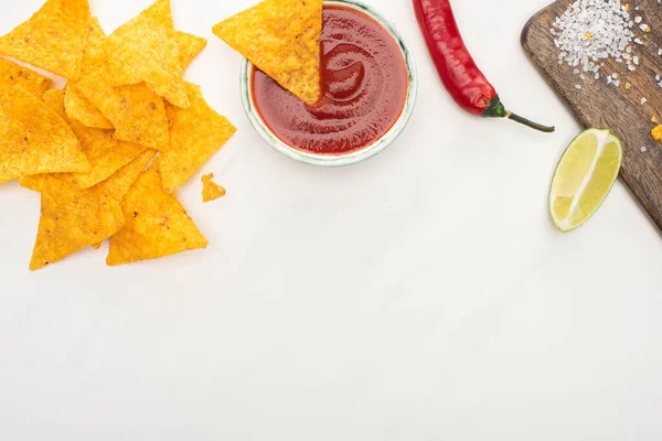 Ansicht von Mais-Nachos mit Limette, Chili, Ketchup auf weißem Hintergrund — Stockfoto