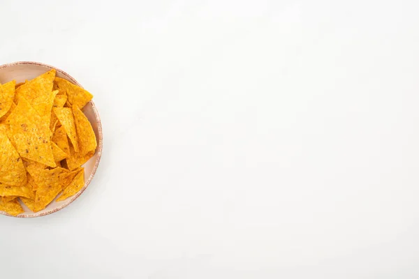 Vue du dessus des nachos de maïs croquants dans un bol sur fond blanc — Photo de stock