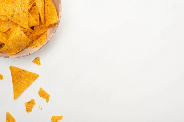 Vue du dessus des nachos de maïs croquants dans un bol sur fond blanc — Photo de stock