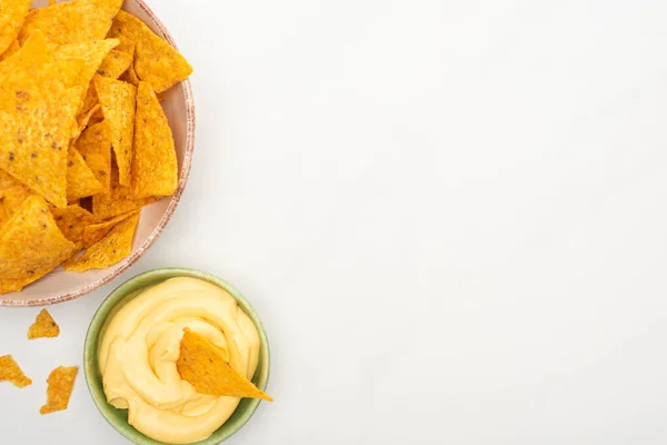 Vista superior de nachos de milho com molho de queijo no fundo branco — Fotografia de Stock