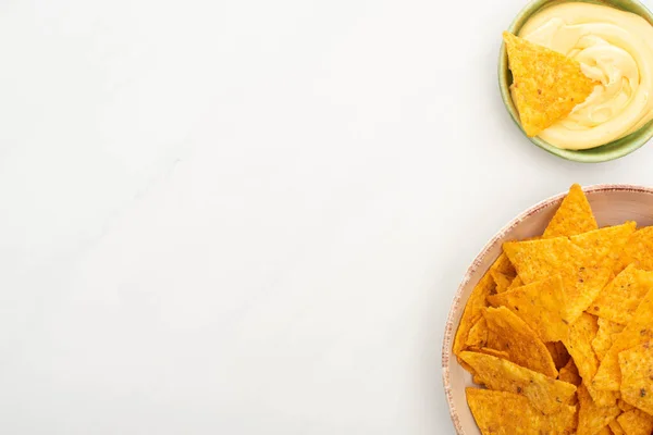 Vista dall'alto di nachos di mais con salsa di formaggio su sfondo bianco — Foto stock