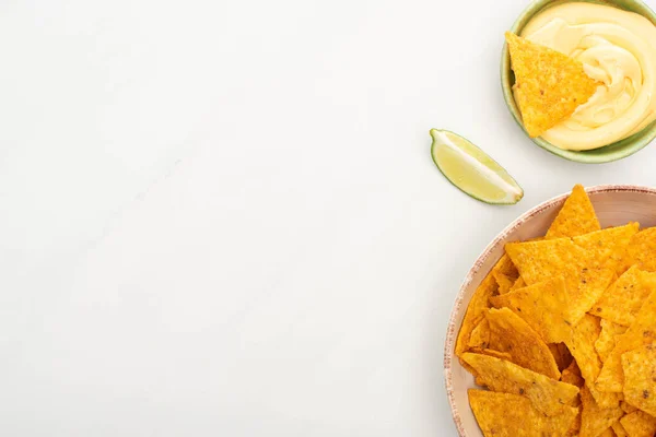 Vista superior de nachos de maíz con salsa de limón y queso sobre fondo blanco - foto de stock