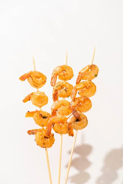 Savoureuses crevettes frites sur brochettes sur fond blanc — Photo de stock