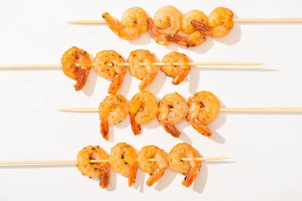 Top view of prawns on skewers on white background — Stock Photo