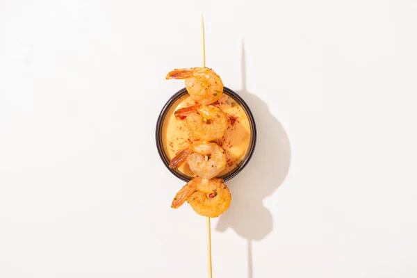 Top view of delicious fried prawns on skewer with sauce on white background — Stock Photo