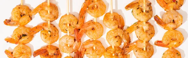 Vue de dessus de délicieuses crevettes frites sur brochettes sur fond blanc, culture panoramique — Photo de stock