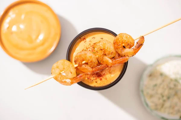 Selective focus of delicious fried prawns on skewer with sauce on white background — Stock Photo