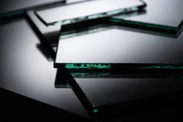 Close up view of mirror pieces in stack on black background — Stock Photo
