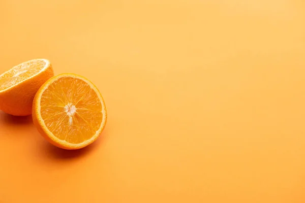 Reife köstliche Orangenhälften auf buntem Hintergrund — Stockfoto