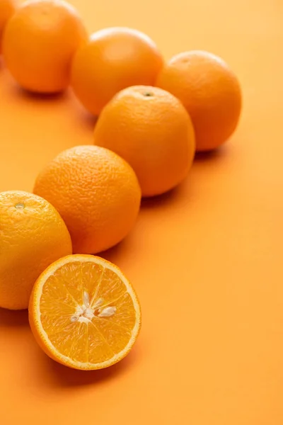 Foco seletivo de todo suculento maduro e laranjas cortadas em fundo colorido — Fotografia de Stock