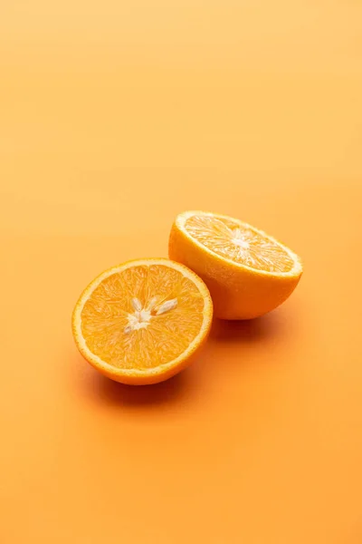 Madura jugosas mitades de naranja sobre fondo colorido - foto de stock