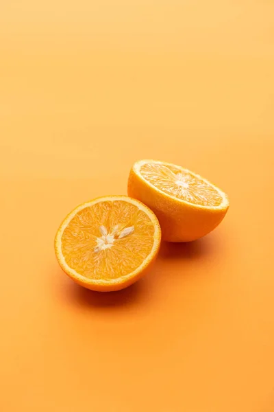 Ripe juicy orange halves on colorful background — Stock Photo