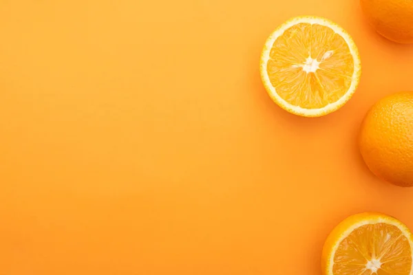 Top view of juicy whole oranges and slices on colorful background — Stock Photo