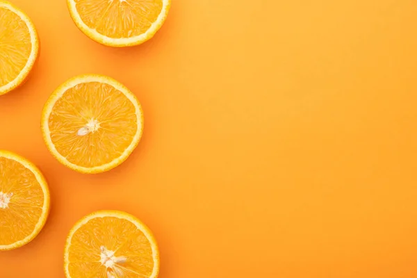 Вид зверху стиглих соковитих апельсинових скибочок на барвистому фоні з пробілом для копіювання — стокове фото
