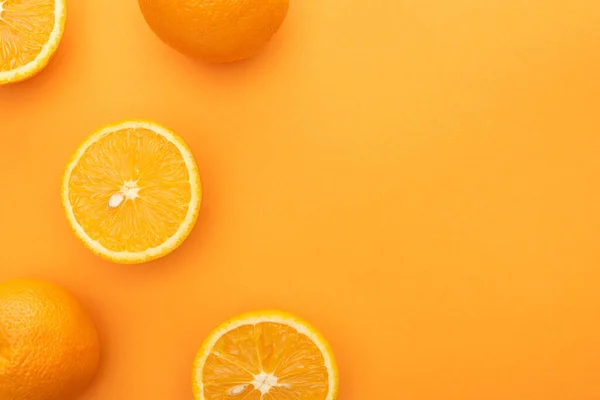 Top view of ripe juicy whole oranges and slices on colorful background — Stock Photo