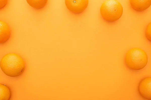 Vue de dessus des oranges entières juteuses mûres sur fond coloré — Photo de stock