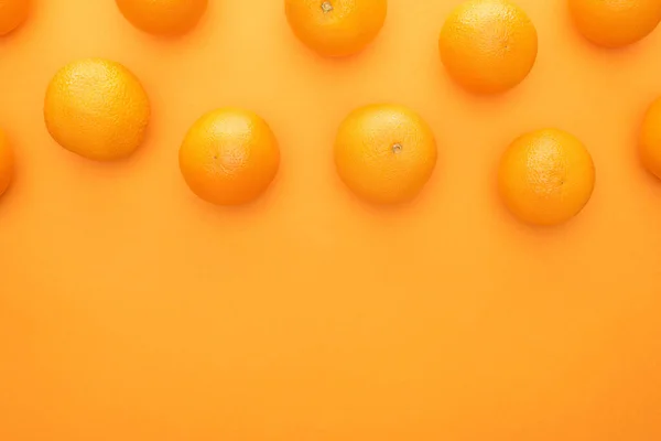 Vista superior de naranjas enteras jugosas maduras sobre fondo colorido - foto de stock