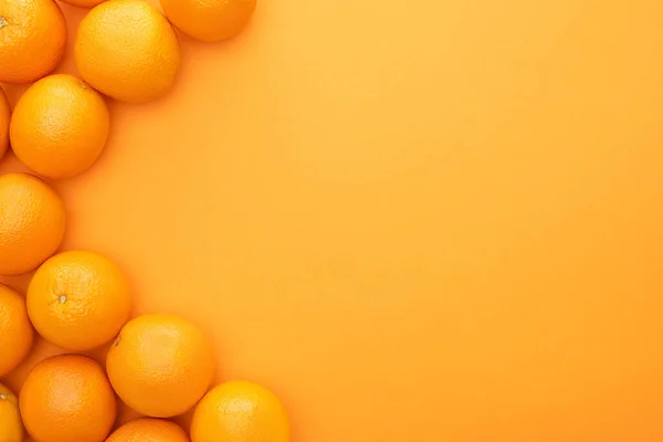 Vue de dessus des oranges entières juteuses mûres sur fond coloré avec espace de copie — Photo de stock